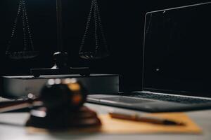 image of judge's hammer, scales lady of justice, law book, laptop computer and contract documents with pen concept of law and justice. photo