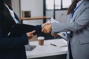 Real estate broker agent and customer shaking hands after signing contract documents for realty purchase, Bank employees congratulate, Concept mortgage loan approval. photo