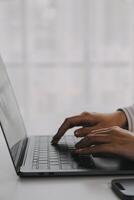 Business woman using mobile phone during working on laptop computer, surfing the internet, searching business data at modern office. Asian businesswoman online working on computer at workplace photo