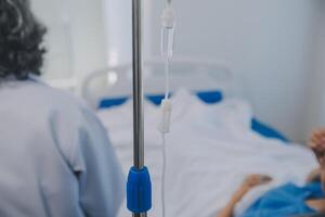 Asian Doctor make routine health check with patient in hospital ward photo