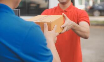 Asian delivery express courier young man use giving boxes to woman customer he wearing protective face mask at front home photo