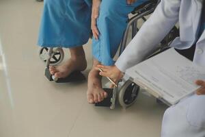 young asian physical therapist working with senior woman on walking with a walker photo