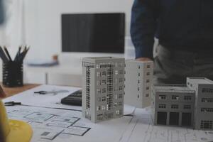 concepto de construcción y estructura de reunión de ingenieros o arquitectos para el proyecto que trabaja con socios y herramientas de ingeniería en la construcción de modelos y planos en el lugar de trabajo, contrato para ambas empresas. foto