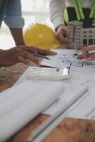 concepto de construcción y estructura de reunión de ingenieros o arquitectos para el proyecto que trabaja con socios y herramientas de ingeniería en la construcción de modelos y planos en el lugar de trabajo, contrato para ambas empresas. foto
