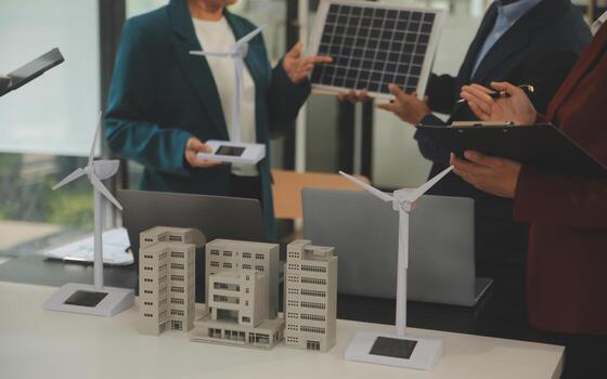 Close-up at tablet, Engineers pointing at tablet with their hands. To jointly design the use of renewable energy with wind and solar energy. Concept of using renewable energy. photo