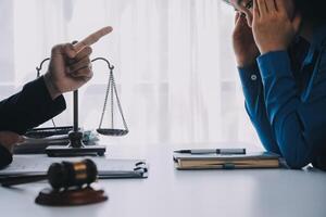 Justice and Law concept. Legal counsel presents to the client a signed contract with gavel and legal law or legal having team meeting at law firm in background photo