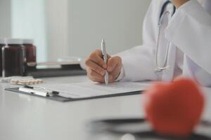 Hands of doctor woman holding red heart, showing symbol of love, human support to patient, promoting medical insurance, early checkup for healthcare, cardiologist help. Close up of object photo