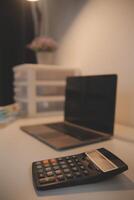 Laptop and paperwork on conference table photo