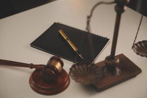 image of judge's hammer, scales lady of justice, law book, laptop computer and contract documents with pen concept of law and justice. photo