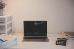 Laptop and paperwork on conference table photo