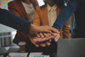 equipo de joven asiático empresarios y puesta en marcha tener negocio reunión y alentador cada otro para bueno espíritu energía a realizar exitoso márketing plan concepto foto