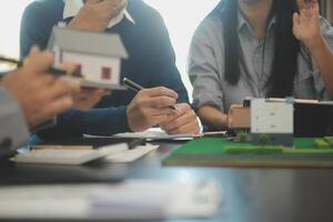 Team of architectures and businessmen discussing and brainstorming on floor plan modification for real estate investment and housing development project photo