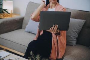 portátil de trabajo de mujer asiática. mujer de negocios ocupada trabajando en una computadora portátil en la oficina. foto