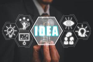 Idea concept, Businessman hand holding lightbulb with idea icon on virtual screen. photo