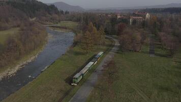 Antenne Aussicht von das Zug Fahrten auf das Eisenbahn. Drohne Flug Über das Lokomotive und Wagen von das eng Spur Eisenbahn. video