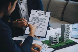 Real estate agent talked about the terms of the home purchase agreement and asked the customer to sign the documents to make the contract legally, Home sales and home insurance concept. photo