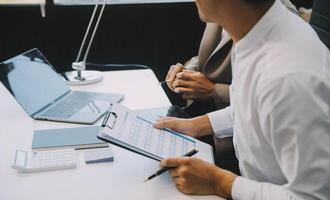 Business team working with new startup project plan and discussion information for financial strategy with laptop and digital tablet in a modern business lounge. photo