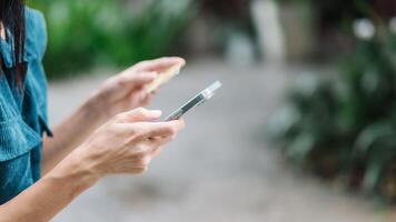 Close up view of a woman hands holding a credit card and a smartphone, likely engaging in an online transaction. photo