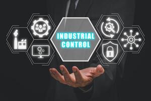 Industrial control concept, Businessman hand holding industrial control icon on virtual screen. photo