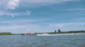 en båt med turister rusar snabbt längs de flod. äldre turism. turister i liv jackor. video