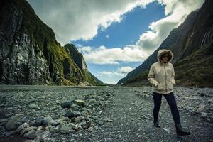woman wearing sweater walking at franz josef glacier southland new zealand photo