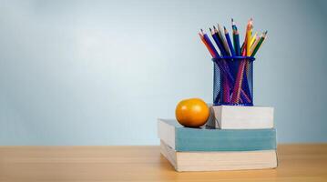 Stack of colorful textbooks and a glass of bright pencils on a white background, Concept of education, training, School tools, workspace, copy space, Banner design education concept background. photo