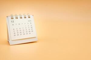 Simple desk calendar for November 2024 isolated on orange background. Calendar concept with copy space. photo