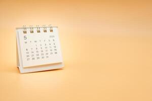 Simple desk calendar for May 2024 isolated on orange background. Calendar concept with copy space. photo