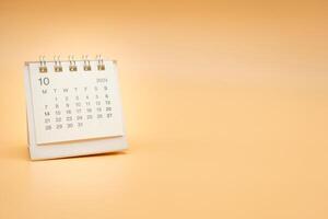 Simple desk calendar for October 2024 isolated on orange background. Calendar concept with copy space. photo