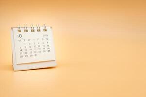 Simple desk calendar for October 2024 isolated on orange background. Calendar concept with copy space. photo
