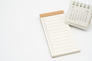 Blank Check list or Empty small notepad for text with checkbox and Simple desk calendar for JULY 2024. Blank to do list for text in July. Copy Space. photo