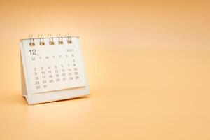 Simple desk calendar for December 2024 isolated on orange background. Calendar concept with copy space. photo