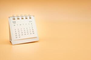 Simple desk calendar for December 2024 isolated on orange background. Calendar concept with copy space. photo