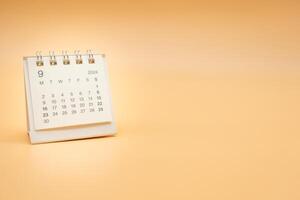 sencillo escritorio calendario para septiembre 2024 aislado en naranja antecedentes. calendario concepto con Copiar espacio. foto