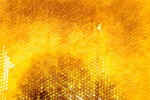 Drop of bee honey drip from hexagonal honeycombs filled with golden nectar photo