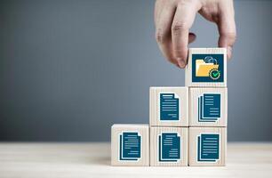 Document database management and Document Management System DMS. Folder and document symbols on wooden cube. with copy space photo