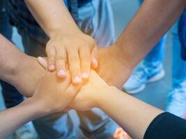 Top view of hands joined together. Concept of unity and teamwork photo