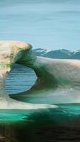 A large iceberg floating on top of a body of water video