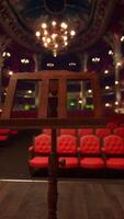 een leeg theater met rood stoelen en kroonluchters video