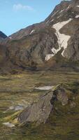 A mountain range covered in snow and grass video