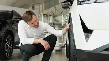 A man examine vehicle before making purchase. Buy car video