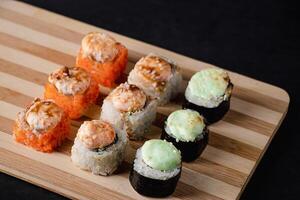 Set of sushi rolls on bamboo serving tray. Uramaki and futomaki roll photo