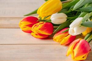 Fresh multicolored tulips on wooden background. Bouquet of spring flowers. photo