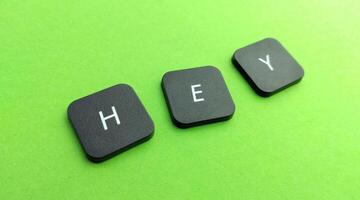 Keyboard keys spelling the word hey on a green background with copy space photo