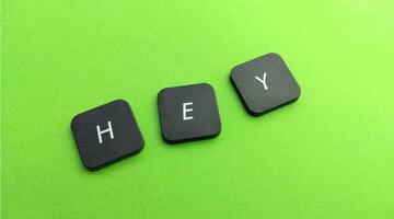 Keyboard keys spelling the word hey on a green background with copy space photo