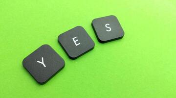 word yes on black buttons on a green background, business and finance concept photo