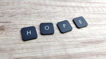 The word hope in black and white letters on a wooden background. photo