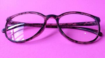 Glasses on a pink background. View from above. Place for text. photo