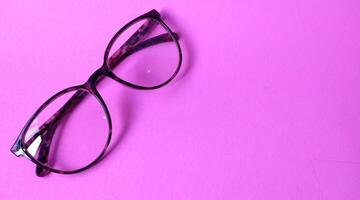 Glasses on a pink background. View from above. Place for text. photo