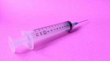Syringe on a pink background. Close-up. Copy space. photo